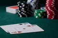 Casino chips and pair of aces on the green table. Poker game Royalty Free Stock Photo