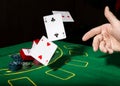 Casino chips and a precious ring on green poker table background, man throws cards with losing combination. Royalty Free Stock Photo