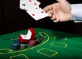 Casino chips and a precious ring on green poker table background, man throws cards with losing combination. Royalty Free Stock Photo