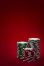 Casino and gambling concept with three stacks of chips of different colors red, green and white/ grey isolated on a red felt Royalty Free Stock Photo