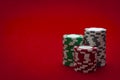 Casino and gambling concept with three stacks of chips of different colors  red, green and white/ grey isolated on a red felt Royalty Free Stock Photo