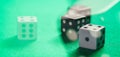 Casino, gambling. White and black dice on green felt abstract background Royalty Free Stock Photo