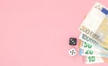 Casino, gambling and fortune concept - close up of black and white dice and euro money on pink background with copy space Royalty Free Stock Photo