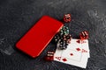 Casino play online concept. Playing chips, cards, three red dices and smartphone