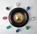 Casino roulette isolated on white and chips for betting around Royalty Free Stock Photo