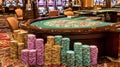 Casino Chips Stacked by Roulette Table with Slot Machines in Background Royalty Free Stock Photo