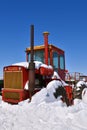 Old Versatile tractor covered with snow Royalty Free Stock Photo