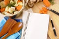 Casserole pot with organic vegetables and herbs on kitchen worktop with cookbook or recipe book Royalty Free Stock Photo