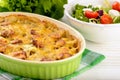 Casserole with potatoes, sausages, tomatoes and cheese.