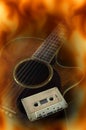 Cassette on acoustic guitar,fire flame screen. Royalty Free Stock Photo