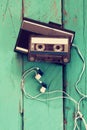 Cassette and old tape player over wooden background. retro filter Royalty Free Stock Photo