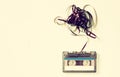 Cassette tape over wooden table with tangled ribbon. top view. retro filter