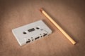 Cassette tape with pencil for rewind on brown paper background. Vintage style Royalty Free Stock Photo