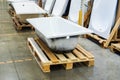 Cast iron bathtub on a wooden pallet in a specialist store. Wholesale and retail plumbing trade. Foreground. Selective focus