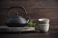 Cast iron black teapot and two bowls of tea