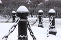 Cast iron fence posts with chains, covered with snow Royalty Free Stock Photo