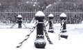 Cast iron fence posts with chains, covered with snow Royalty Free Stock Photo