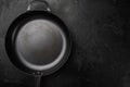 Cast iron frying pan with copy space for text or food with copy space for text or food, top view flat lay , on black dark stone Royalty Free Stock Photo