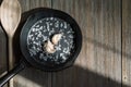 Cast iron frying pan with salt and garlic on a rustic loft wooden table. Kitchen food background with copy space for Royalty Free Stock Photo