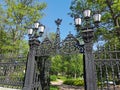 Cast-iron grating, fence, gates and lanterns in the Summer Garden of Kronstadt against the background of a blue cloudless sky Royalty Free Stock Photo