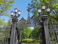 Cast-iron grating, fence, gates and lanterns in the Summer Garden of Kronstadt against the background of a blue cloudless sky Royalty Free Stock Photo