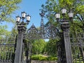 Cast-iron grating, fence, gates and lanterns in the Summer Garden of Kronstadt against the background of a blue cloudless sky Royalty Free Stock Photo