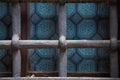 Cast Iron grid on window with blue stained glass. Background and wallpaper picture. Square geometrical composition. Copy