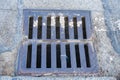 Cast-iron manhole of the storm sewer system on the road in front of the asphalt Royalty Free Stock Photo