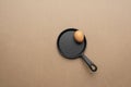 Cast iron pan and egg on a brown background. Royalty Free Stock Photo