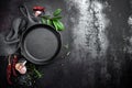 Cast iron pan and spices on black metal culinary background