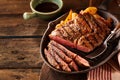 Cast iron plate with sliced grilled rib-eye steak on table