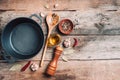 Cast iron pot, spices, pepper shaker, meat fork, oil, spices on wooden background. Top view. Copy space. Healthy, clean food and