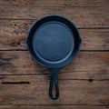 The cast-iron skillet frying pan flat lay on shabby wooden background with copy space . Royalty Free Stock Photo