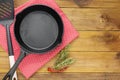Cast iron skillet frying pan, on a rustic wooden background. Top view. Cooking process. Menu or recipe mock up