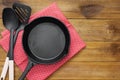 Cast iron skillet frying pan, on a rustic wooden background. Top view. Cooking process. Menu or recipe mock up Royalty Free Stock Photo