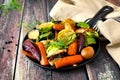 Skillet of roasted vegetables against rustic wood Royalty Free Stock Photo