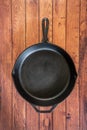 Cast iron skillet on wooden surface - top view with copy space