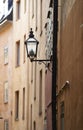 Cast iron street light in an alley way in a rural town in Europe. Empty street with glass lantern on tall buildings or Royalty Free Stock Photo