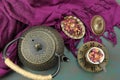 A cast iron teapot kettle with a cup of Rose tea and some rose petals Royalty Free Stock Photo
