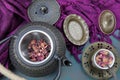 A cast iron teapot kettle with a cup of Rose tea and some rose petals Royalty Free Stock Photo