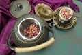 A cast iron teapot kettle with a cup of Rose tea and some rose petals Royalty Free Stock Photo