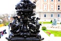 cast iron, wrought iron and forged steel decorative, ornate shiny black lamppost detail. soft blurred stone building elevation Royalty Free Stock Photo