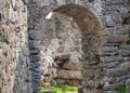 Castel ruin arch of gray stone old building way out of it on a stone masonry labyrinth amid the ruins