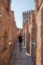 Castelvecchio Italian: `Old Castle` brick view of the walls and a tourist waking with his camera