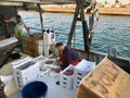 A fisherman is sorting his catch on an anchored fishing-boat