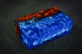 blue epoxy resin with nature burl BURMA PADAUK wood cube on black background Royalty Free Stock Photo