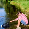 Casting that fish off. man with fish on rod. big game fishing. relax on nature. successful fisherman in lake water Royalty Free Stock Photo