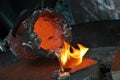 Casting liquid aluminium from crucible into sand form