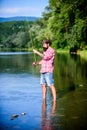 Casting off. mature bearded man with fish on rod. successful fisherman in lake water. hipster fishing with spoon-bait Royalty Free Stock Photo