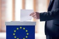 Casting a vote: a man\'s hand with a ballot in EU parliamentary elections